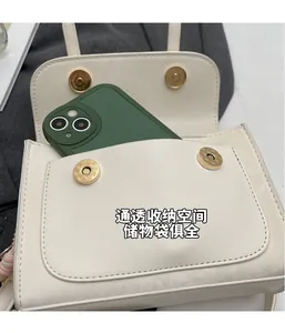 Dettaglio dello spazio interno della mini borsa beige con smartphone e chiusura magnetica