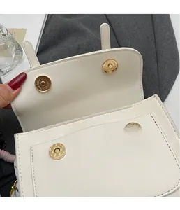Dettaglio borsa in ecopelle color crema con doppia chiusura magnetica dorata