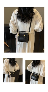 Detail of vintage matte black crossbody bag with gold buttons and striped scarf handle