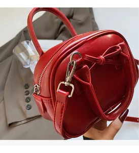 Detail of red oil-wax leather bowling bag with shiny metallic hardware and zipper