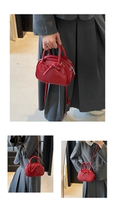 Detail view of red bow bowling bag with glossy finish and adjustable shoulder strap