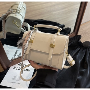 Macro detail of creamy white matte faux leather bag with vintage gold hardware