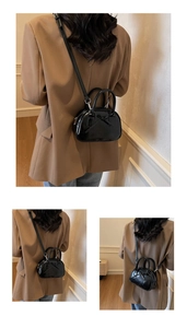 Close-up of black glossy bow handbag with smooth patent leather and detachable strap