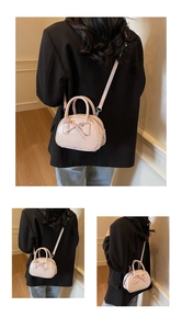 Detail of pink glossy mini bowling bag with bow accent and detachable shoulder strap