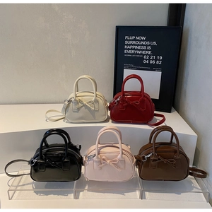 Detailed row of mini bowling bags with bow knots in cream, red, black, pink, and brown
