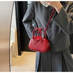 Detail of red oil wax leather bowling bag featuring a 3D bow and silver hardware finish