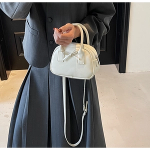 Detail of white PU leather bowling bag with bow decoration and silver metal hardware