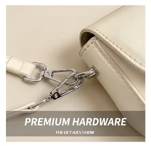 Close-up of polished silver metal hook and premium stitching on cream leather bag