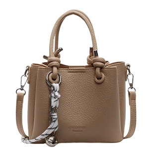 Beige minimalist top-handle square bag with litchi texture and decorative bell charm