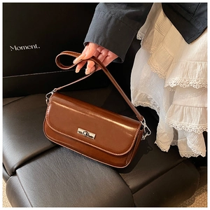 Close-up of a vintage brown baguette bag with a silver metallic twist-lock closure