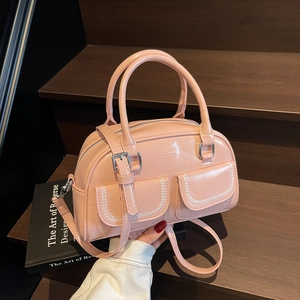 Pink glossy leather Boston bag with crossbody strap and double front pockets