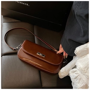 Detailed top view of a dark brown glossy baguette bag with a silver rotating metal lock