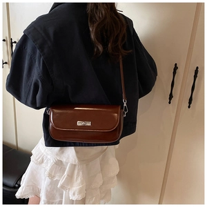 Detail of dark brown vintage baguette bag with silver twist lock on model side view