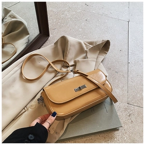 Detail of camel rectangle baguette bag with silver metal twist lock and smooth texture
