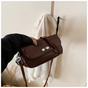 Detailed view of dark coffee baguette bag with silver twist lock and leather strap