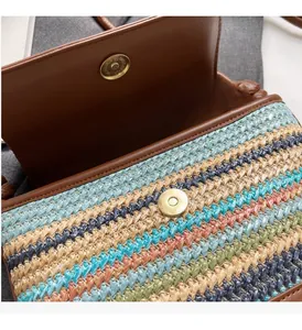 Close-up of multicolored woven straw bag with premium leather trim and gold magnetic closure