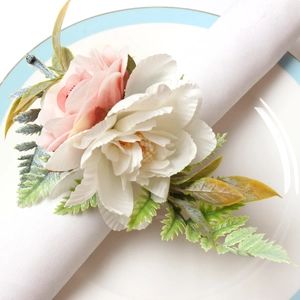 Elegant white peony and pink rose napkin ring with green leaves on white linen napkin