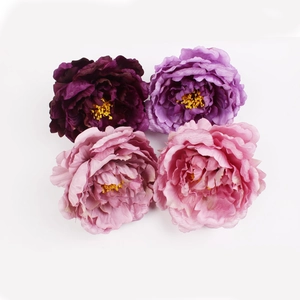 Close-up of four colorful artificial peony napkin rings on a white background