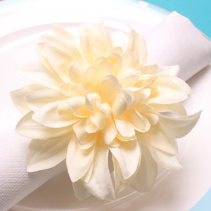 Detailed macro view of an off-white silk dahlia napkin ring on a white plate