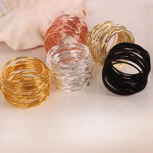 Detailed close-up of wire-wrapped metal napkin rings in gold, silver, and rose gold finishes