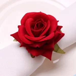 Macro view of a realistic red velvet rose napkin ring with green leaves detail