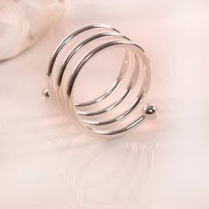Detail view of a silver multi-layer spiral napkin ring with smooth metallic ball finials