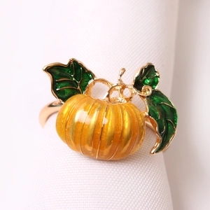 Golden pumpkin napkin ring with yellow enamel and green leaves for Halloween decor