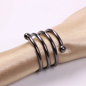 Detail shot of black nickel spiral napkin ring with spheres on champagne satin fabric