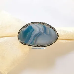 Macro shot of blue agate napkin ring with crystal rim and clear acrylic stand base