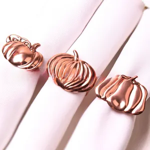Detail of rose gold pumpkin napkin rings with realistic texture on white linens