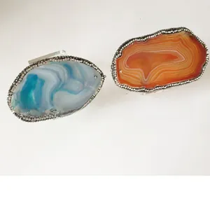 Macro detail of blue and orange natural agate napkin rings with crystal diamond edges
