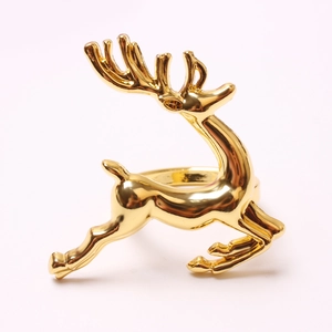 Close-up of golden deer napkin ring with mirror finish on soft background