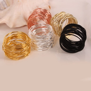 Detailed view of wire-wrapped napkin rings in gold, silver, rose gold and black finish