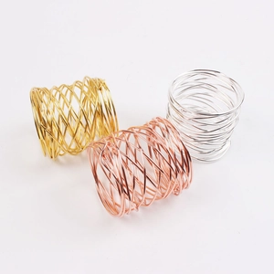 Detail of handcrafted wire-wrapped napkin rings in gold, silver, and rose gold finishes