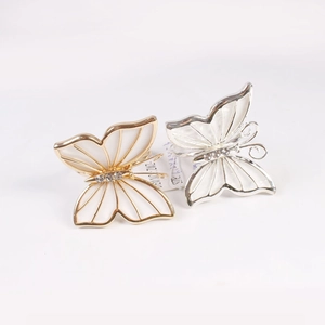 Elegantes servilleteros de mariposa dorados y plateados con cristales y esmalte blanco