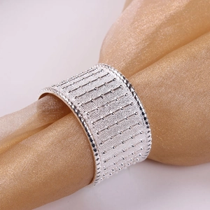 Silver beaded alloy napkin ring with textured metal lines on gold silk fabric