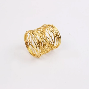 Macro view of gold wire woven napkin ring featuring intricate handmade metal craftwork