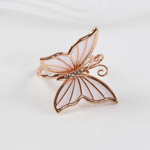 Vista detallada de un servilletero de mariposa en oro rosa con esmalte blanco y cristales