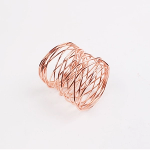 Macro view of rose gold handcrafted wire mesh napkin ring with intricate woven design