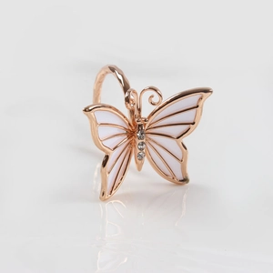 Servilletero de mariposa dorada con alas de esmalte blanco y piedras de circonita