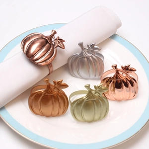 Detailed macro view of pumpkin-shaped metal napkin rings in various metallic finishes