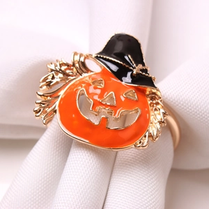 Macro detail of pumpkin witch hat napkin ring with vibrant orange enamel and gold base