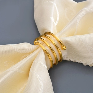 Elegant gold spiral napkin ring with double beads on premium textured fabric decor