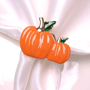 Macro detail of pumpkin napkin rings with orange enamel and gold finish for fall tables