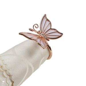 Servilletero de mariposa oro rosa con esmalte blanco y cristales sobre encaje