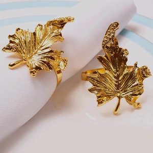 Macro detail of golden maple leaf napkin ring showing intricate metal veins on a plate