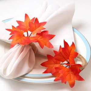 Close-up of fall maple leaf napkin ring with rustic jute rope on white dinner napkin