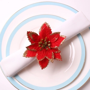 Gros plan d'un rond de serviette poinsettia rouge avec paillettes dorées sur assiette