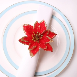 Détail d'un rond de serviette poinsettia en velours rouge avec paillettes dorées