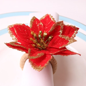 Détail du rond de serviette de Noël en velours rouge avec bordure dorée et base tissée